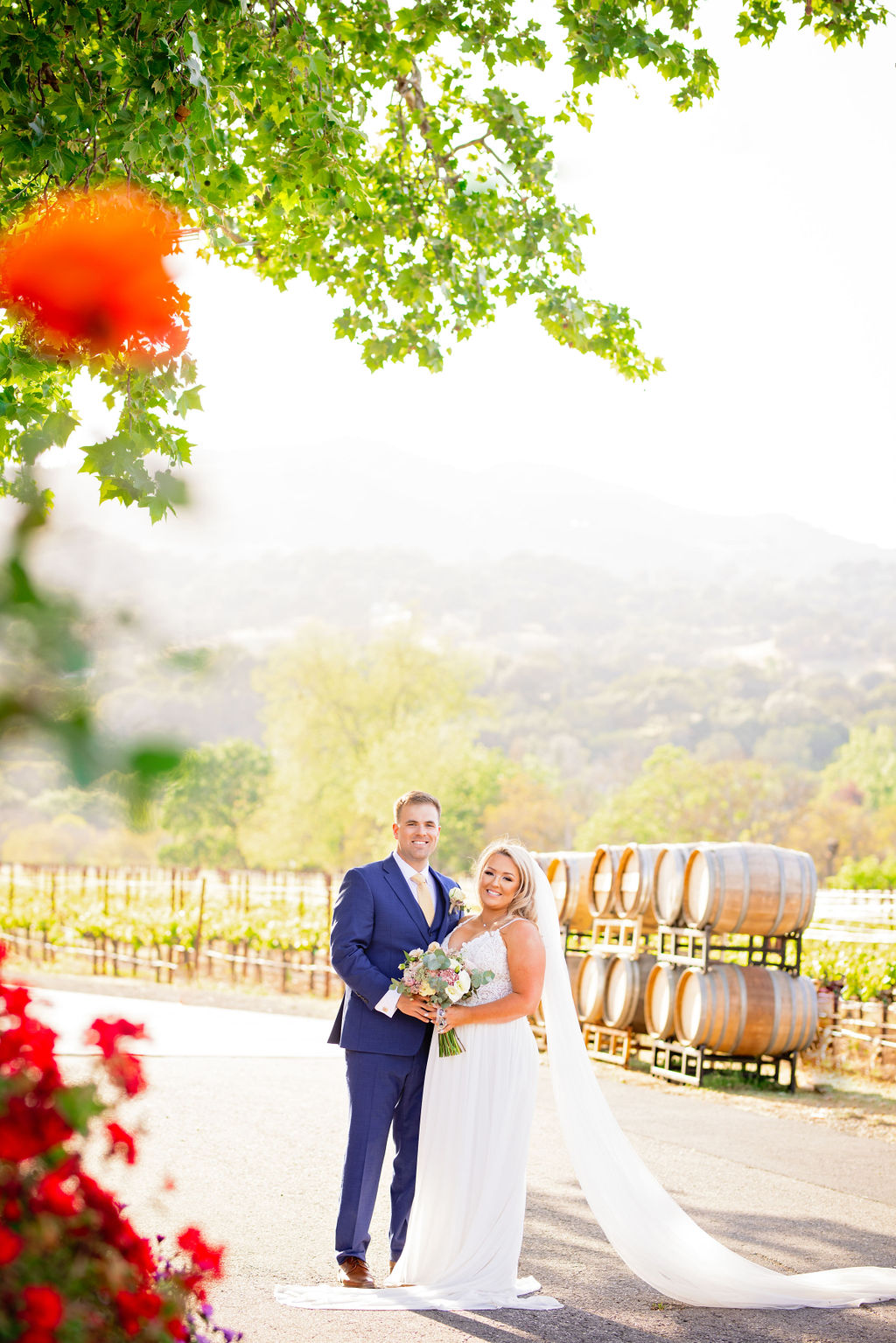 bride and groom standing in front of wine barrels at their Napa CA Wedding Venues 