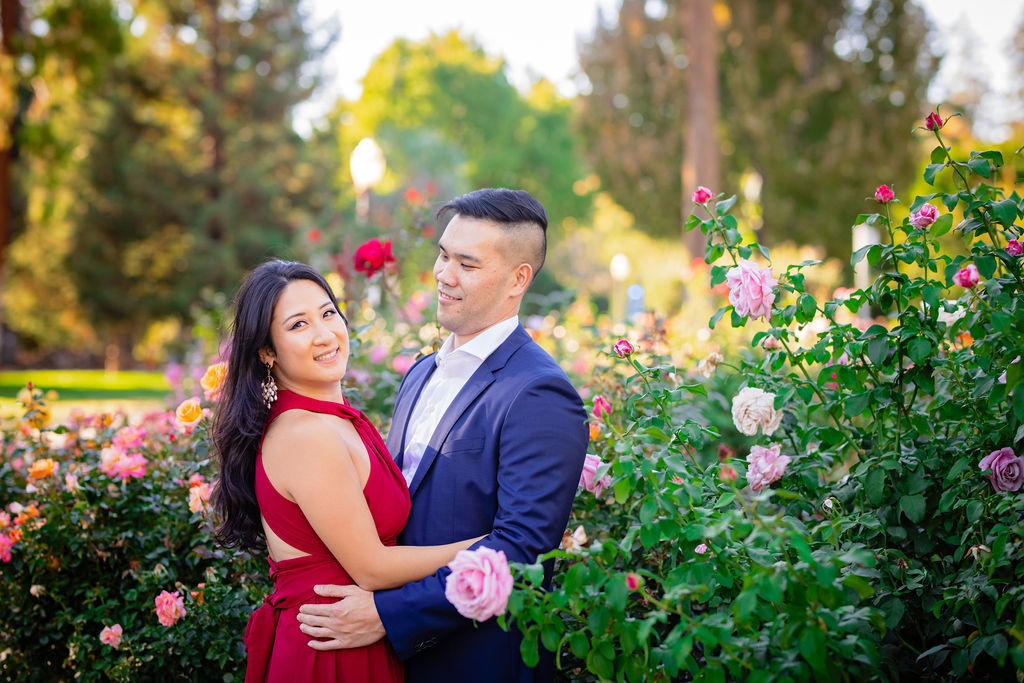 Couple in red and navy in a garden at Capitol Park Sacramento Engagement Photo Locations