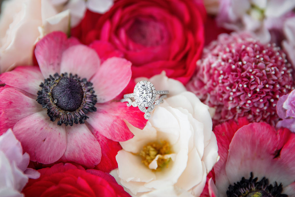 Wedding rings in red, pink, and white flowers