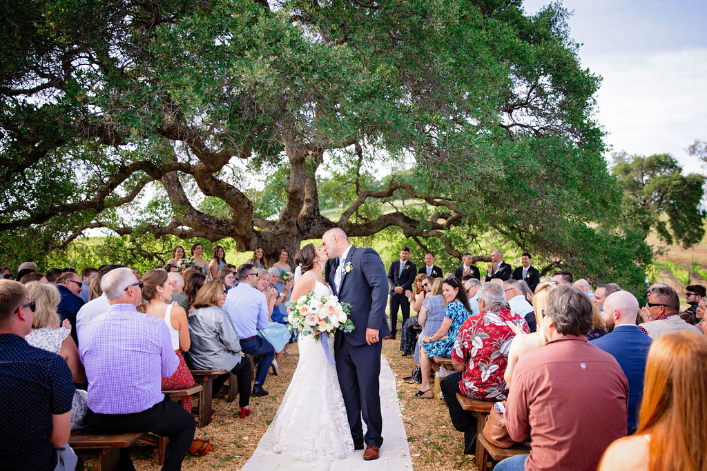 Bride and groom sharing a kiss down the aisle at outdoor wedding venues in Sacramento