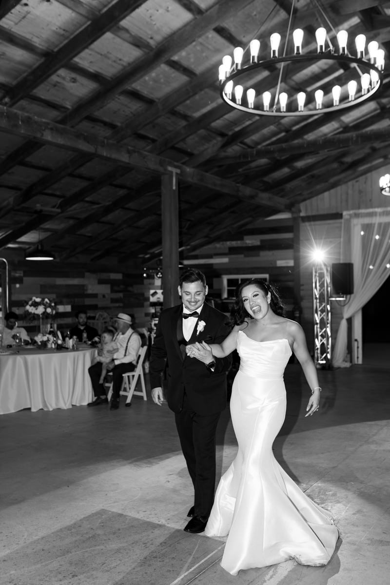 Bride and groom grand entrance in the barn on their wedding day at the barn at twin ponds with sacramento wedding photographer ashley teasley