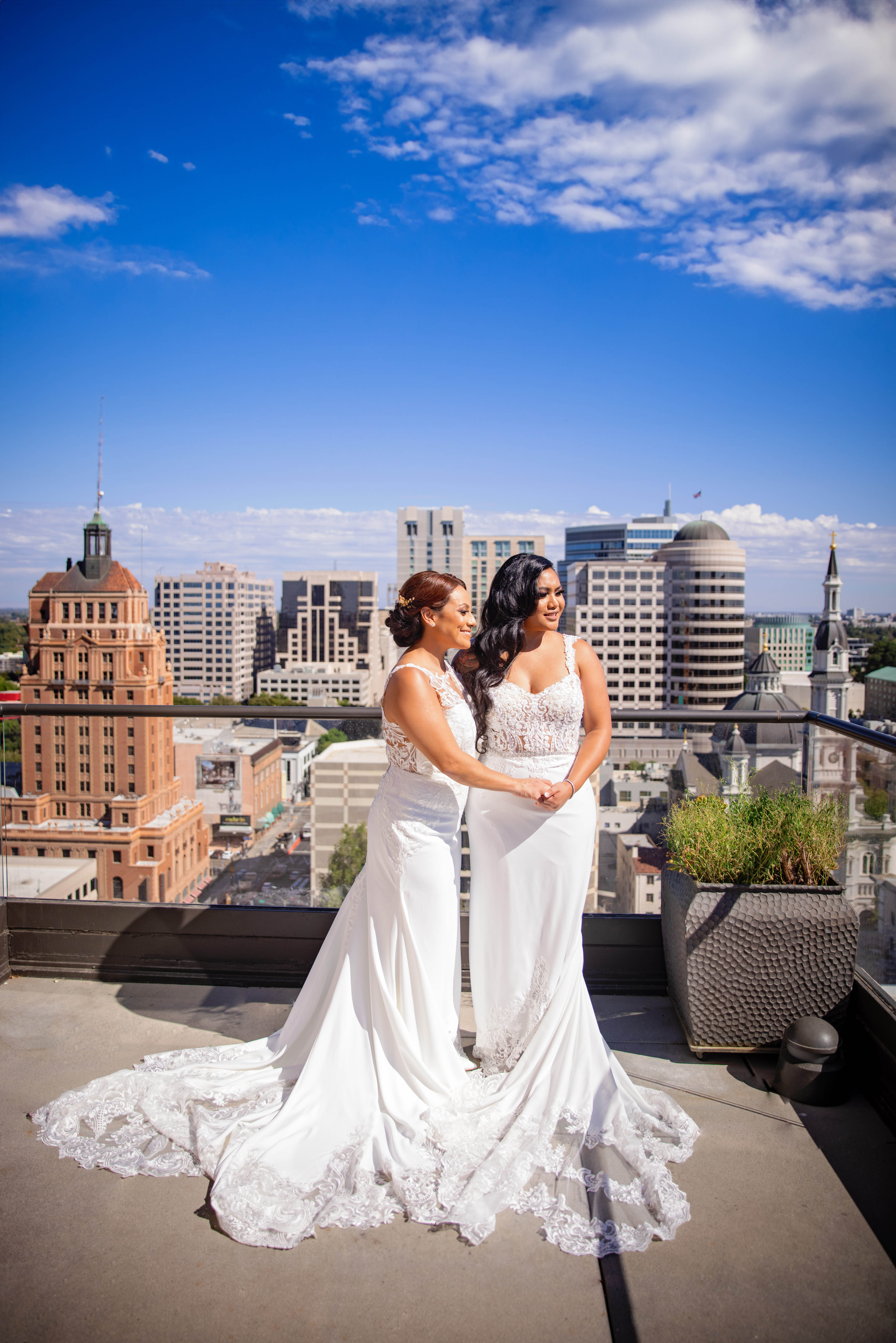 two brides embracing at the top of the citizen hotel wedding venue on their sacramento wedding day
